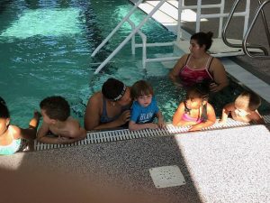 kids in pool with teachers